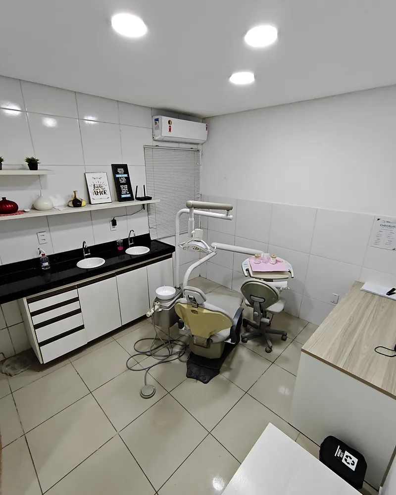 Consultório da Oral Sollution com cadeira odontológica bege e bancada preta