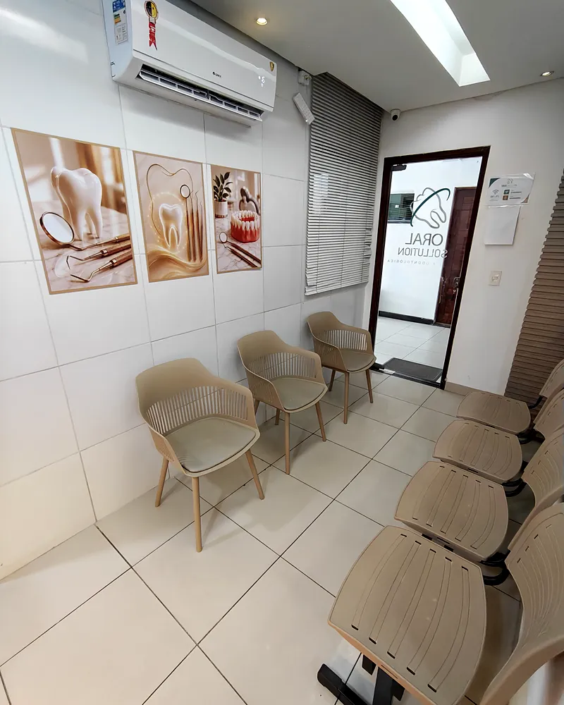 Sala de espera da Oral Sollution com poltronas e quadros na parede